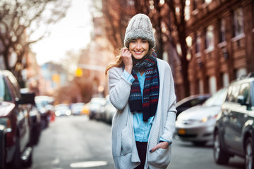 Beautiful smiling woman walking on city street wearing casual style clothes