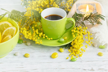 mimosa, lemon and coffee on light wooden background