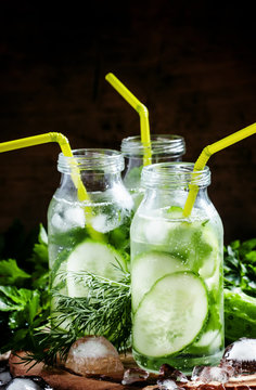Refreshing cold drink of cucumber and herbs in glass bottles, se