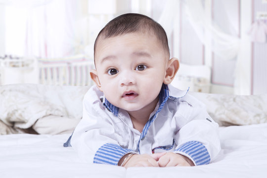 Cute baby boy crawling in the bedroom