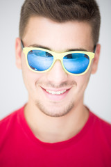 Young man with colored sunglasses