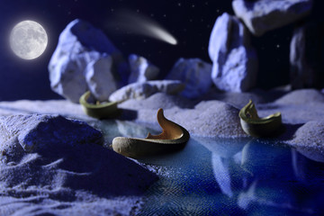 Łodzie w zatoce nocą, księżyc, kometa, skały.