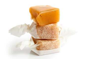 Stack of three wrapped vanilla caramel toffees isolated. One unw