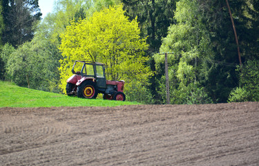 Fototapeta premium Old tractor on spring field