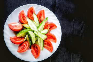 sliced cucumbers and tomatoes and vegetables on a plate