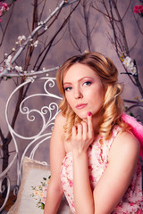 Portrait of young beautiful woman in angel costume with pink win