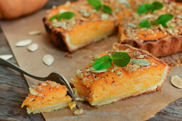 pumpkin tart with cream and cinnamon on rustic background