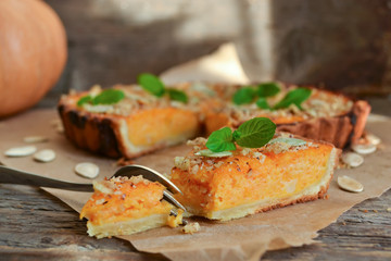pumpkin tart with cream and cinnamon on rustic background
