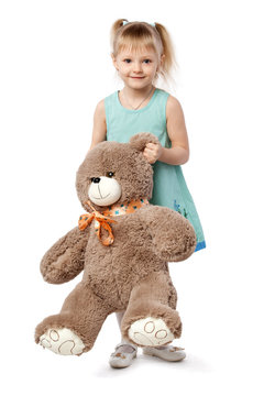 Portrait of a little blonde girl in a blue dress with a soft bea