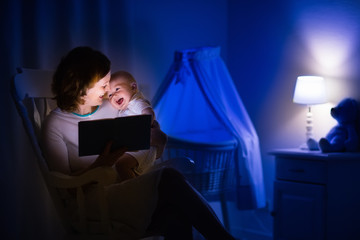 Mother reading a book to little baby
