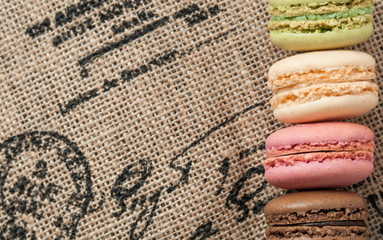 Close up macaroons on the jute tablecloth with space for text