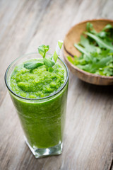 Rucola smoothie, on the grey  background.
