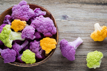 Rainbow of eco cauliflower on the wooden table.