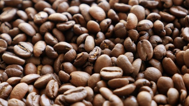 Fresh roasted arabica coffee beans on table slow tilt 4K 2160p 30fps UHD video - Slow tilting over a lot of Arabic type coffee beans 4K 3840X2160 UltraHD footage 