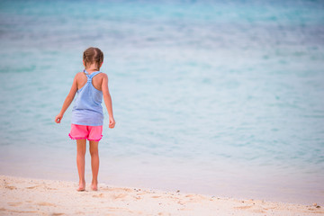Fototapeta na wymiar Little girl at beach during summer vacation