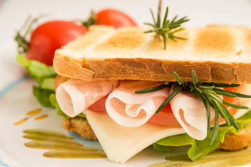 Toasted sandwich with bacon, cheese, tomato and lettuce