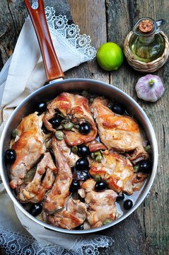 Roast rabbit in white wine with rosemary, olives and capers