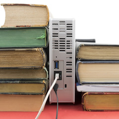 Several old books on a bookshelf together with a high capacity network hard drive looking as...