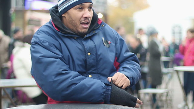 Drunk manual worker is cold outdoors, man looking at people with smirk on face