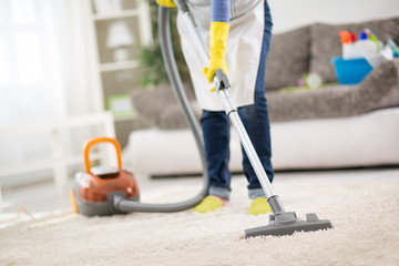 Housewife clean carpet with vacuum cleaner