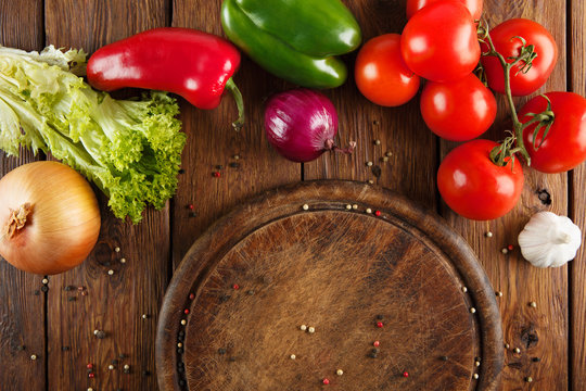 Various vegetables for pizza at wooden background