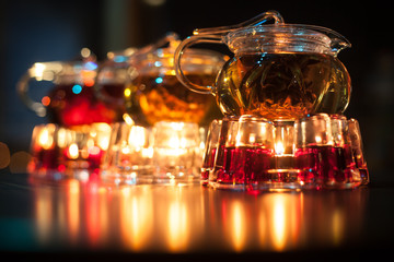 Fototapeta na wymiar three glass teapots with candle heaters;