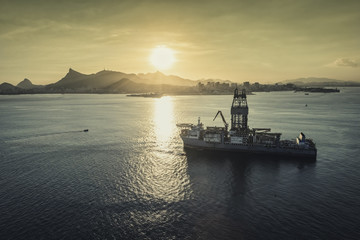 Oil drilling rig against panorama of Rio De Janeiro at sunset