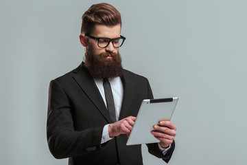 Bearded businessman with gadget