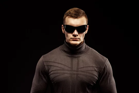Combat muscled action hero man wearing shirt with pants and sunglasses.  Studio shot. Robocop Style Stock Photo | Adobe Stock