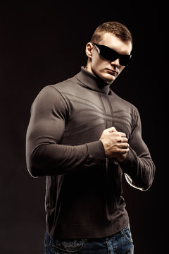 Combat muscled action hero man wearing shirt with pants and sunglasses.  Studio shot. Robocop Style Stock-Foto | Adobe Stock