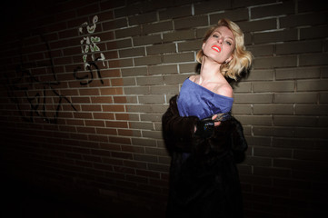 Girl poses near a wall