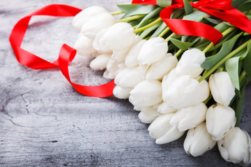 Bouquet white tulips with red ribbon.Flowers of spring and love.Valentine's day.Happy Mothers Day.Copy space.selective focus.