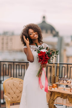 Happy black bride corrects her hair and smiling. Wedding day
