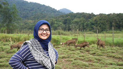portrait of young women in wildlife with deer