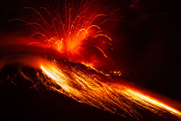 A close-up of a nocturnal volcano eruption at night, with lava exploding from Stromboli, creating a disaster and a panoramic view of the earth shaking.