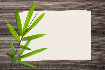 Bamboo leaf and and paper on wood background
