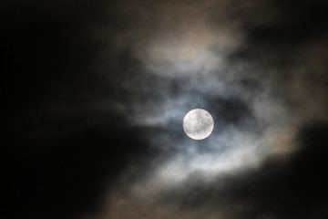 Full moon with dark clouds passing by.