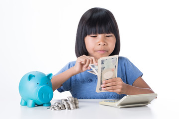 Little girl in t-shirt count japan money at the table , isolated with white background