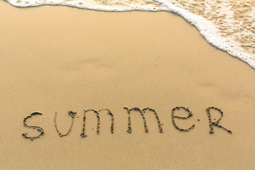 Summer - inscription on sand beach with the soft wave.
