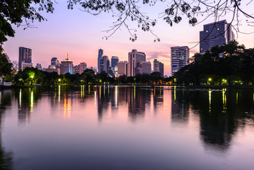 Bangkok skyline and water reflection with urban lake in summer.