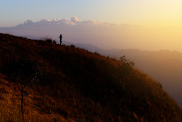 Silhouette man hiker take a photo of mountain view.