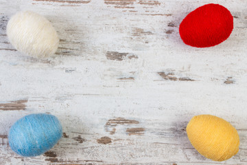Easter eggs wrapped woolen string on wooden background, copy space for text, decoration for Easter