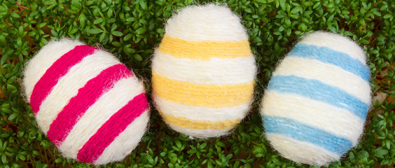 Easter eggs wrapped woolen string and green cress, decoration for Easter