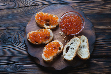 Sandwiches with salmon red caviar in a rustic wooden setting