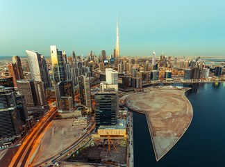 Scenic aerial skyline of Dubai business bay with many modern skyscrapers at sunset.
