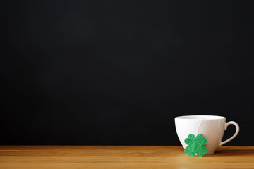 Green clover with white coffee cup