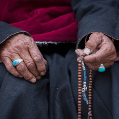 Old Tibetan woman holding buddhist rosary, Ladakh, India. Hand and rosary