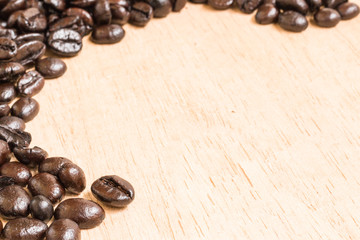 Brown roasted coffee beans on wooden background