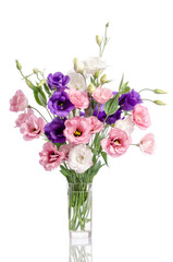 Fototapeta na wymiar bunch of violet, white and pink eustoma flowers in glass vase is