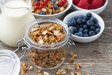 glass jar with granola, milk, and fresh berries 